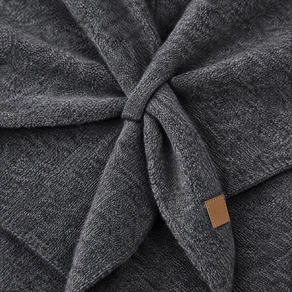 Macro of the soft knit texture and loop of The Loop Shawl in dark grey