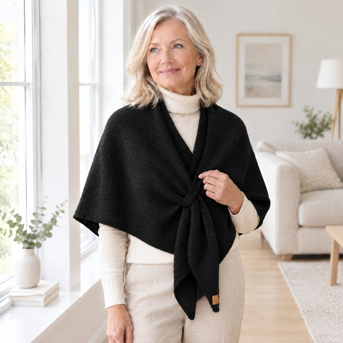 Woman wearing The Loop Shawl in black over a cream turtleneck