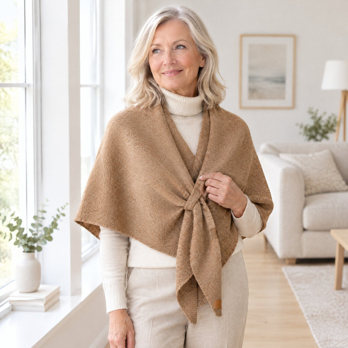 Woman wearing The Loop Shawl in camel over a cream turtleneck