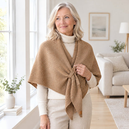 Woman wearing The Loop Shawl in camel over a cream turtleneck