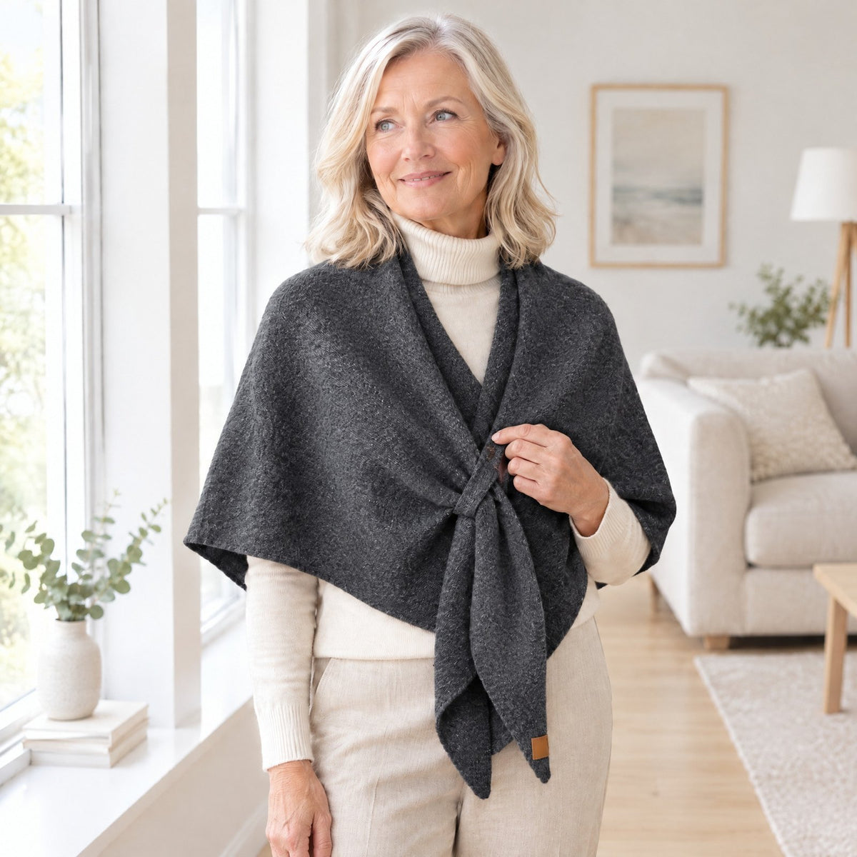 Woman wearing The Loop Shawl in dark grey over a cream turtleneck