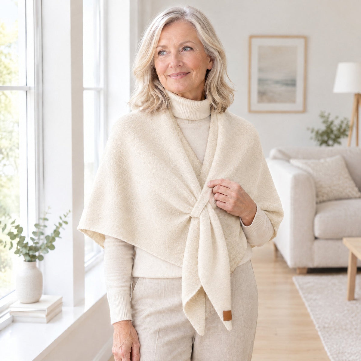 Woman wearing The Loop Shawl in ivory over a cream turtleneck