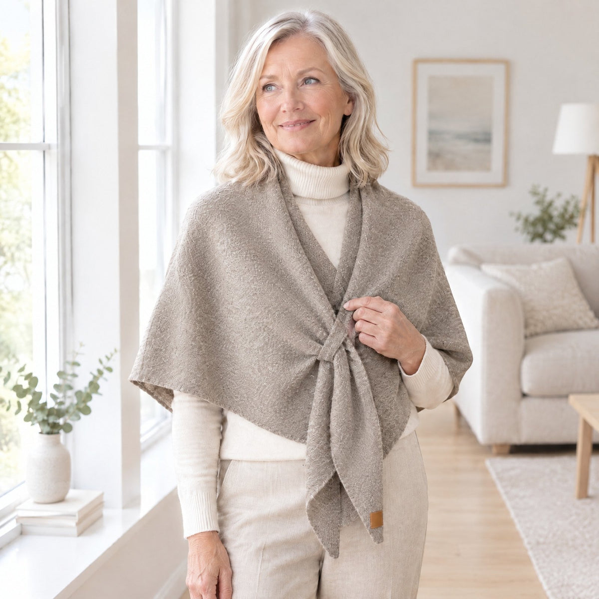 Woman wearing The Loop Shawl in khaki over a cream turtleneck