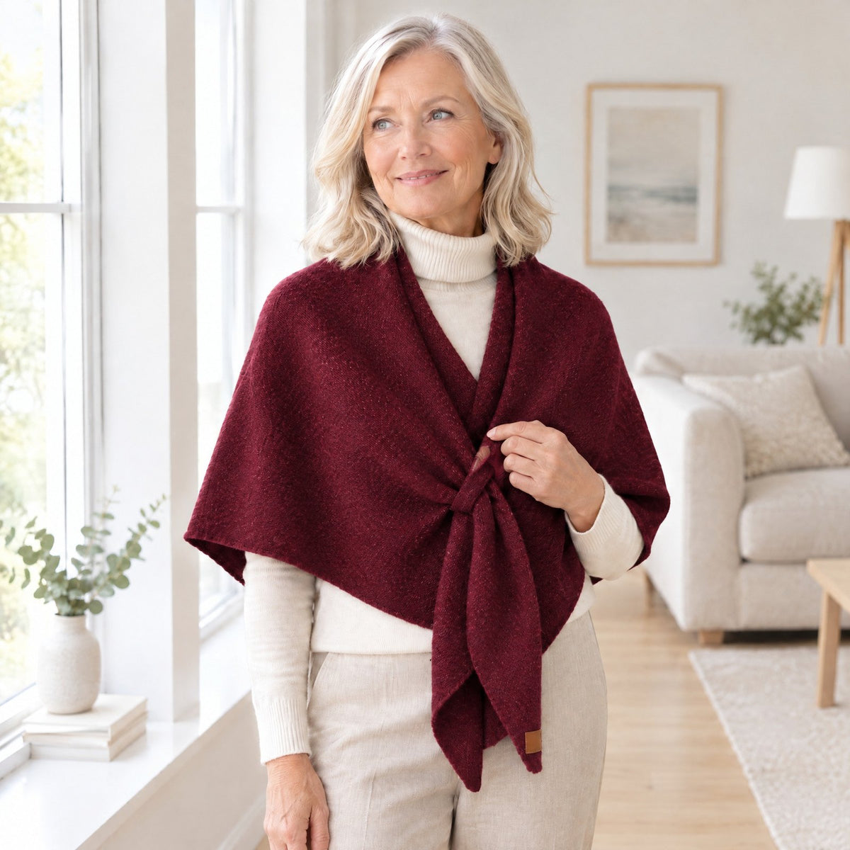Woman wearing The Loop Shawl in wine red over a cream turtleneck